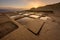 A beautiful golden sunrise landscape photograph of rock-cut salt pans