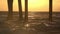 Beautiful golden sunset under a pier on the ocean