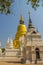 Beautiful golden and white pagodas in Sri Lankan style at Wat Suan Dok (flower garden temple) with blue sky background. Wat Suan D