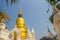 Beautiful golden and white pagodas in Sri Lankan style at Wat Suan Dok (flower garden temple) with blue sky background. Wat Suan D