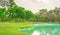 Beautiful and good mainternance of a park under cloudy sky, beauty trees on green grass fresh lawn near a lake