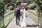 Beautiful gorgeous bride and groom posing in sunny spring park among green leaves. happy wedding couple walking in green garden.