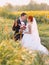 Beautiful gorgeous redhair bride and stylish handsome groom in a sunflower sunny field