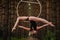 Beautiful and graceful aerial gymnast does exercises on the ring