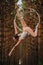 Beautiful and graceful aerial gymnast does exercises on the ring