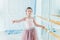 Beautiful graceful ballerina practice ballet positions in pink tutu skirt in dance class