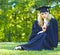 A beautiful graduate sitting on the lawn