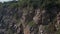 Beautiful granite quarry during the day. Lots of stones. Stones overgrown with trees and grass. Trees sway in the wind. Top view