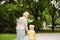 Beautiful granny and her little grandchild walking together in park