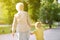 Beautiful granny and her little grandchild walking together in park