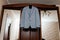 Beautiful gray groom`s suit hanging on wardrobe in the room