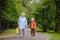 Beautiful gray-haired elderly lady accompanies or pick up baby from school. Friendship of grandmother and grandson. Babysitting