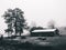 Beautiful grayscale shot of a barn with its yard on a foggy day