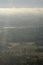 Beautiful green forests and fields pictured from airplane window with blue sky and clouds. Countryside view from airplane in the