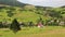 Beautiful green hills and cottage with red roof in village