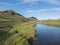 Beautiful green hills, lush grass and blue river next to camping site on Alftavatn lake. Summer sunny day, landscape of