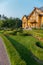 Beautiful green lawn framed by bushes and flowers in front of a large rich mansion, the residence of Yanukovych Museum