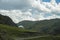 Beautiful green mountains with national Kazakh yurt and cloudy blue sky background. Blue sky.