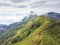 Beautiful green mountains with path road, cloud, and fog