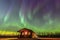 A beautiful green and red aurora dancing over the hut  in Iceland