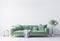 Beautiful green velvet sofa in modern interior space. White  wall background with wooden frame