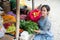 Beautiful greengrocer woman arranges spinach for her vegetable stall display