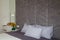 Beautiful grey bedroom, bed, pillows, soft fabric headboard, autumn bouquet of yellow chrysanthemums in green vase near. Modern