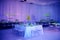 Beautiful guest square table set up for a wedding or social event in the ballroom orchid and lucite chairs draped walls