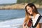 Beautiful guitarist woman playing guitar on the beach