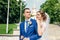 Beautiful guy and girl, bride in a white wedding dress, groom in a classic blue suit against a nature background. Wedding, family