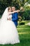 Beautiful guy and girl, bride in a white wedding dress, groom in a classic blue suit against a nature background. Wedding, family