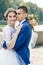 Beautiful guy and girl, bride in a white wedding dress, groom in a classic blue suit against a nature background. Wedding, family