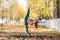 Beautiful gymnast do tricks on a portable platform in a beautiful autumn park. woman dance on a portable pole stage