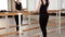 Beautiful gymnast does the splits in a room with ballet lathe and mirrors