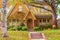 Beautiful half timbered house in Autumn with colorful leaves fallen on green grass acorns on the sidewalk pumpkins on the steps