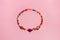 Beautiful handmade beaded bracelet on pink background, top view