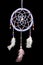 Beautiful handmade dreamcatcher hanging in front of a black background