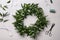 Beautiful handmade mistletoe wreath and florist supplies on white wooden table, flat lay. Traditional Christmas decor