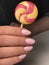 Beautiful hands with manicure hand holding colorful lollipop