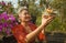 Beautiful and happy Asian Indonesian woman dressed in traditional Balinese religious custom holding incense stick and flowers