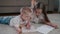 Beautiful happy boy and young girl, brother and sister draw in a notebook