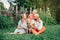 Beautiful happy Caucasian Ukrainian family of four people in park on summer day. Mother and father hugging their two sons
