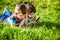 Beautiful happy children, boy brothers, exploring nature with magnifying glass, summertime