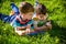 Beautiful happy children, boy brothers, exploring nature with magnifying glass, summertime