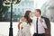 Beautiful happy couple of newlyweds are hugging while walking along the town street. Half-length horizontal portrait.