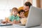 Beautiful happy family with child looking at laptop with cheerful smile