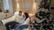 Beautiful happy family of three on the sofa smiling and talking by the Christmas tree on Christmas night.