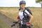 Beautiful and happy girl cyclist with a bike on nature. Healthy lifestyle and sports. Leisure and hobbies