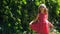 Beautiful happy girl in a red polka dot dress smiling on wild grape background. Cute joyful child with long blonde hair.