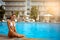 Beautiful happy girl with a smile in a hotel pool in a southern tropical resort